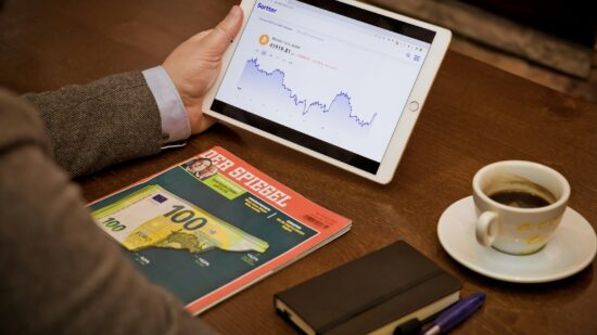 Drinking coffee in a coffee shop checking Bitcoin chart with Der Spiegel, from Germany, aside.